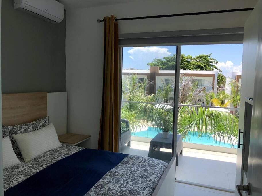 a bedroom with a bed and a view of a balcony at Boca Paraiso, Boca Chica townhouse in Boca Chica