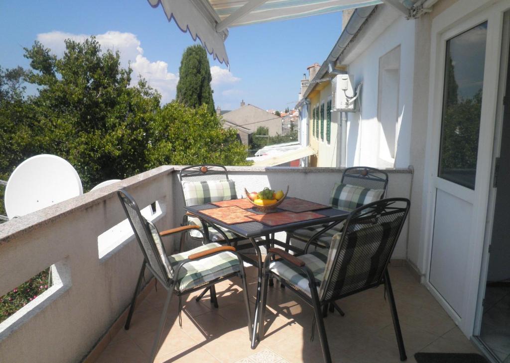een tafel en stoelen op het balkon van een huis bij Apartments with a parking space Punat, Krk - 15451 in Punat