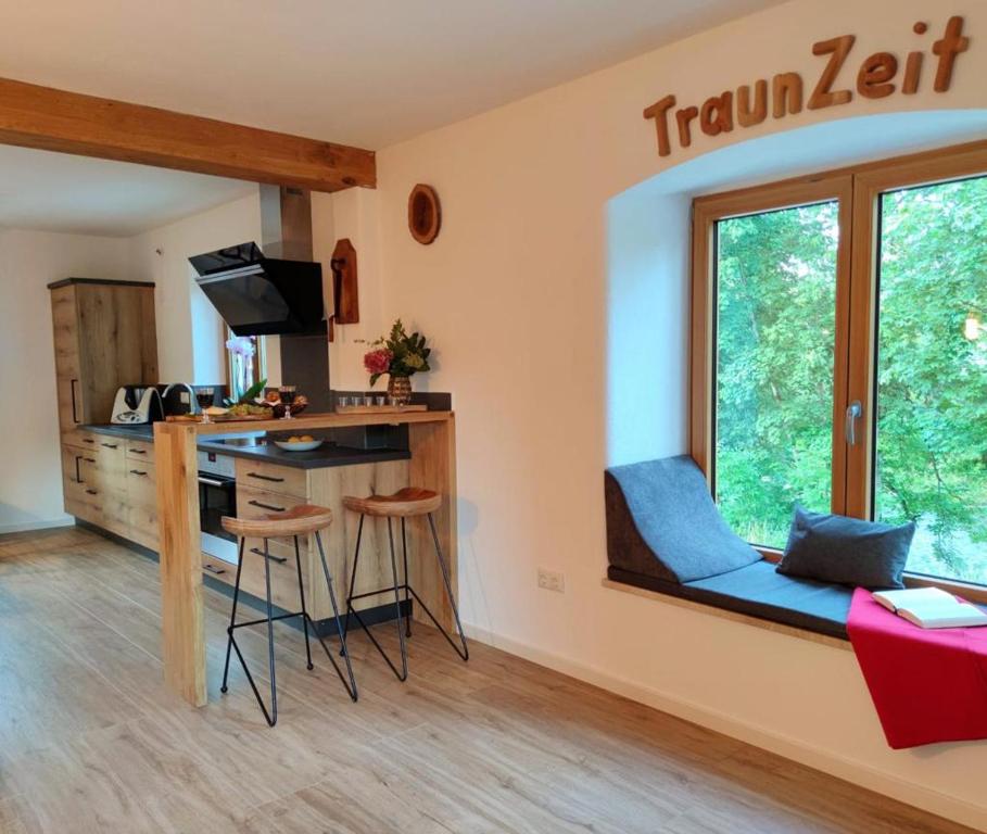 a room with a kitchen with a desk and a window at TraunZeit in Siegsdorf