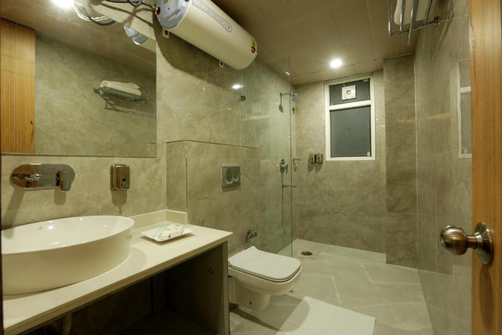 a bathroom with a sink and a toilet and a shower at Hotel Sakura by Maps in Gurgaon