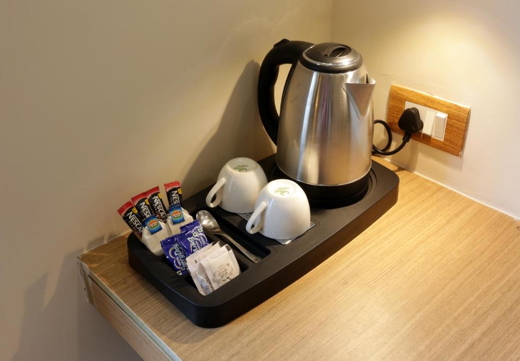 a tea kettle on a black tray on a counter at Hotel Sakura by Maps in Gurgaon