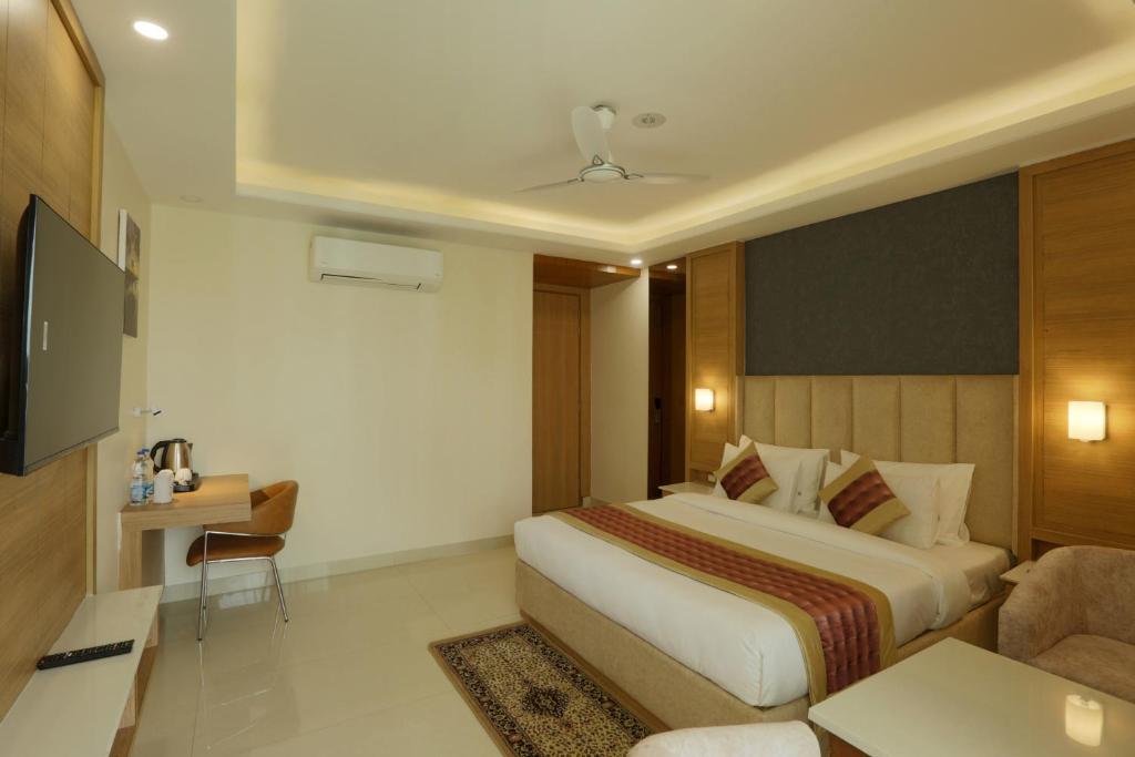 a hotel room with a bed and a television at Hotel Sakura by Maps in Gurgaon
