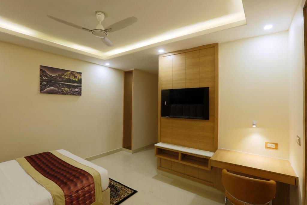a hotel room with a bed and a flat screen tv at Hotel Sakura by Maps in Gurgaon