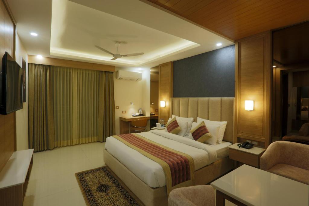 a hotel room with a large bed and a couch at Hotel Sakura by Maps in Gurgaon