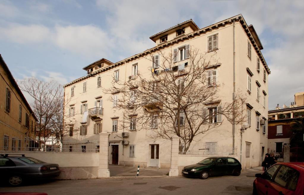 un gran edificio blanco con coches estacionados frente a él en Studio Split 15887a en Split
