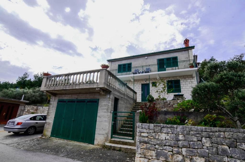 Biały dom z zielonymi drzwiami i płotem w obiekcie Apartments by the sea Prigradica, Korcula - 15792 w mieście Blato