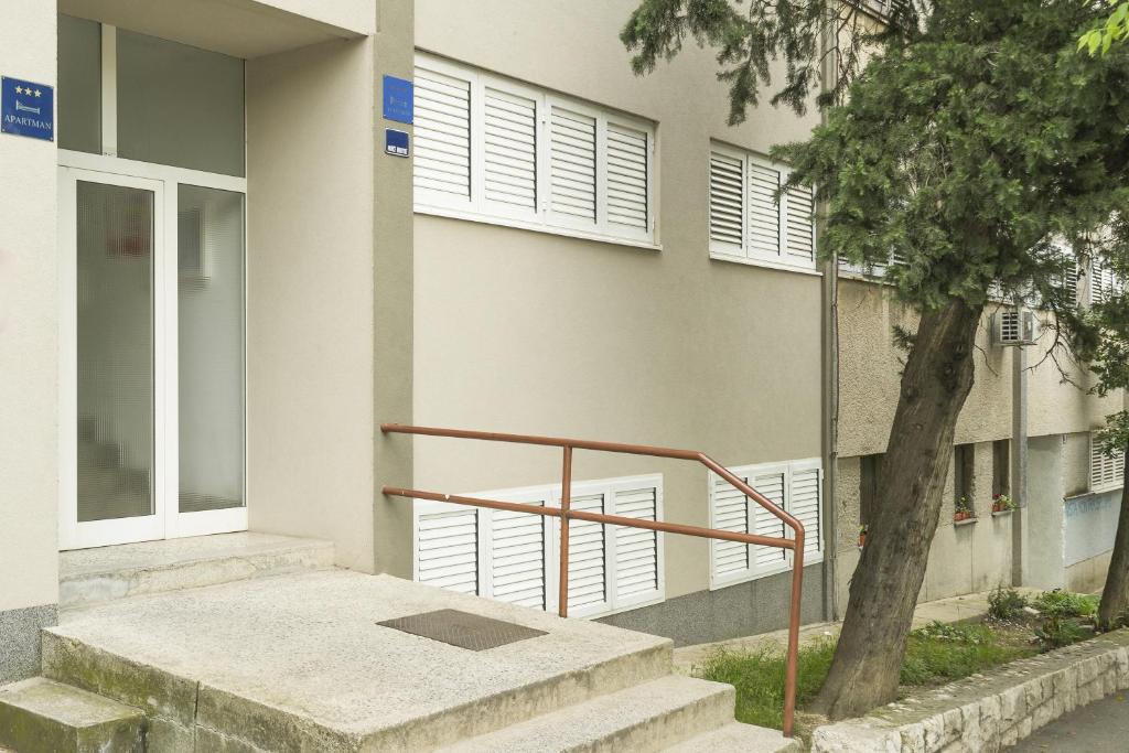 a building with stairs and a tree in front of it at Apartments with WiFi Split - 15862 in Split