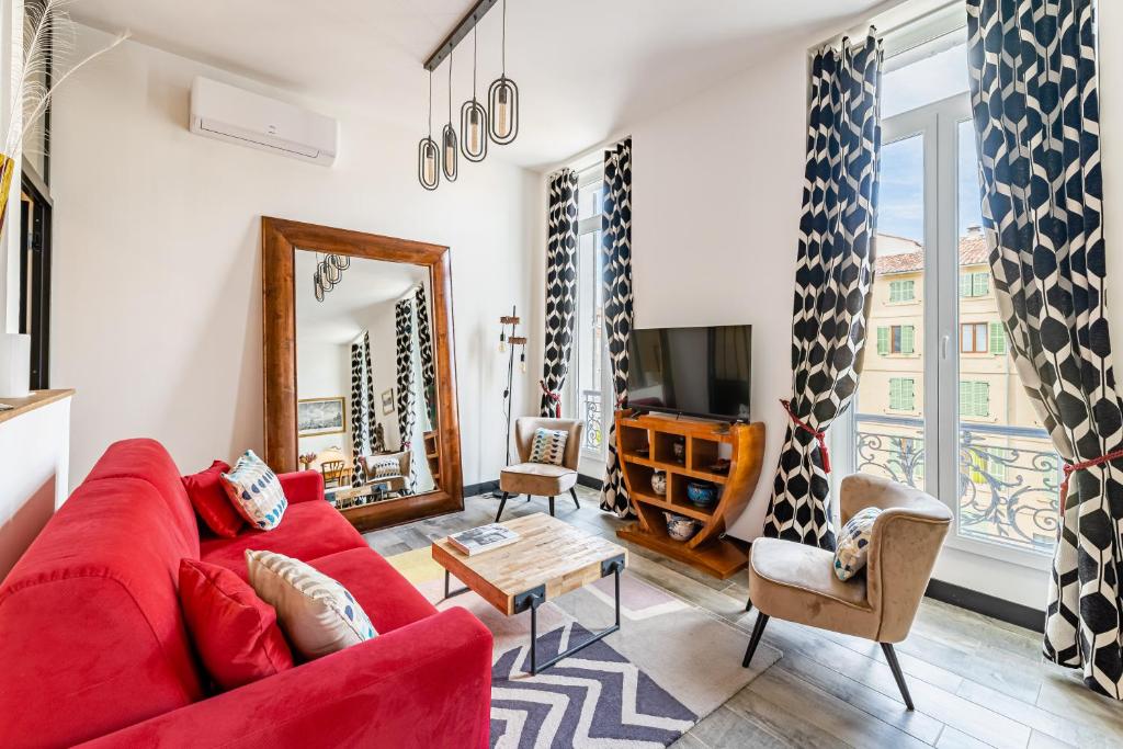 a living room with a red couch and a tv at Vue Vieux-Port et Notre Dame, Atypique, Calme, Clim, T2 Chic 48M2,Accès avec code in Marseille