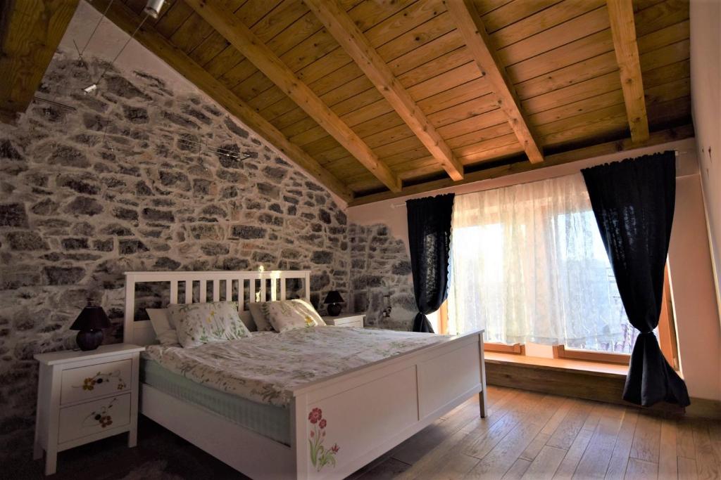 - une chambre avec un lit blanc et un mur en pierre dans l'établissement Family friendly house with a swimming pool Ruzici, Opatija - 16202, à Jurdani