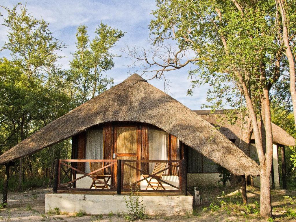una cabaña con techo de paja en el bosque en Lianshulu BUSH Lodge en Kongola