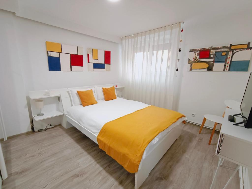 a white bedroom with a bed and a desk at Central Park Apartments in Braşov