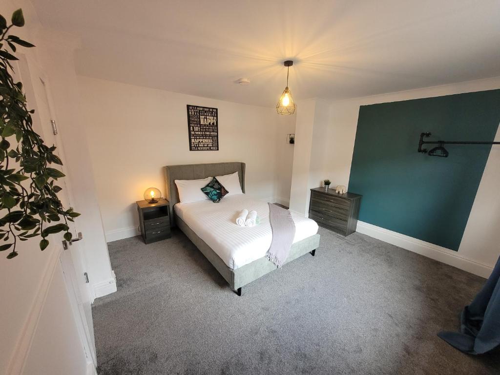 a bedroom with a bed and a green wall at Luke Stays - Parsons Gardens in Dunston