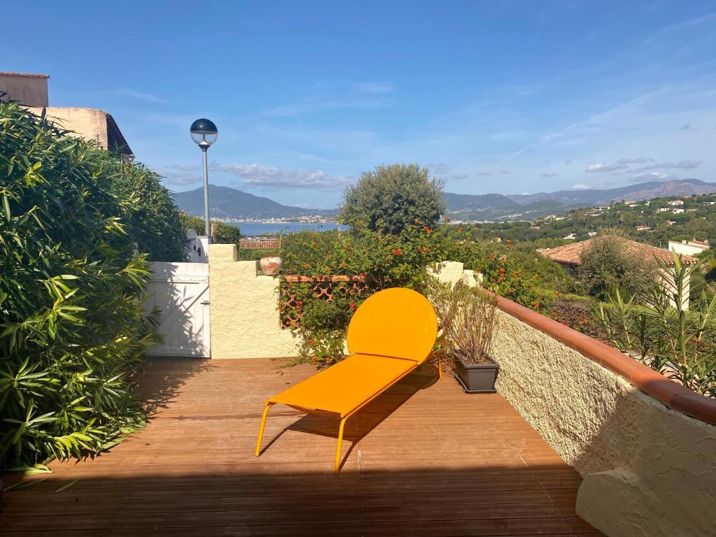 una silla amarilla sentada en una terraza de madera en Terra Bella - mini Villa vue mer, en Grosseto-Prugna