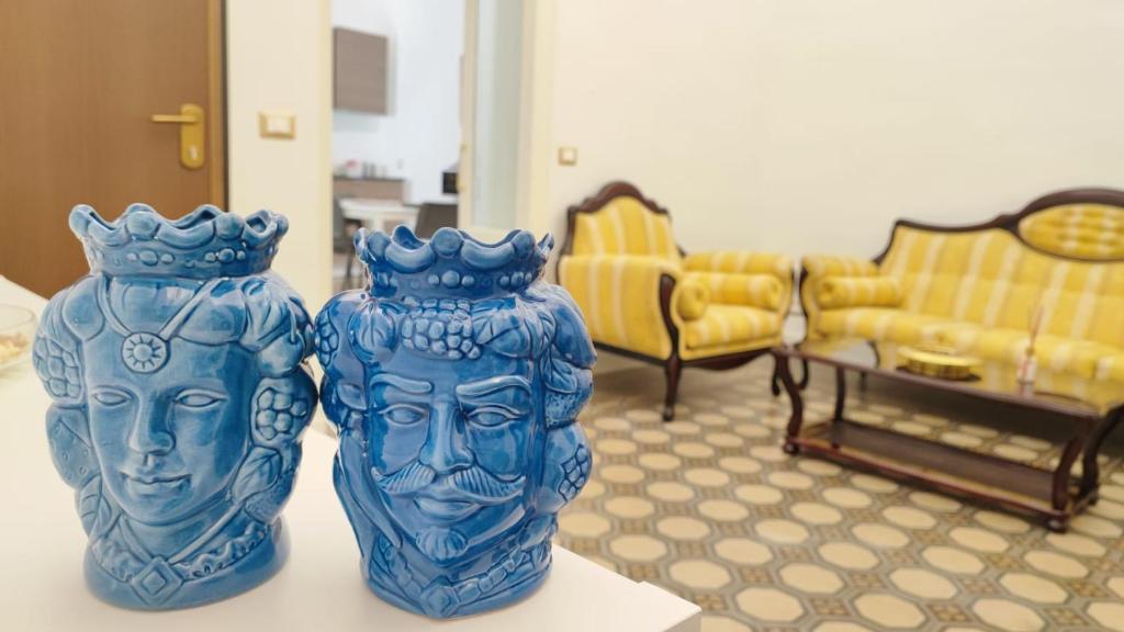 two blue vases sitting on a table in a room at DUHOME apartment in the heart of Catania in Catania