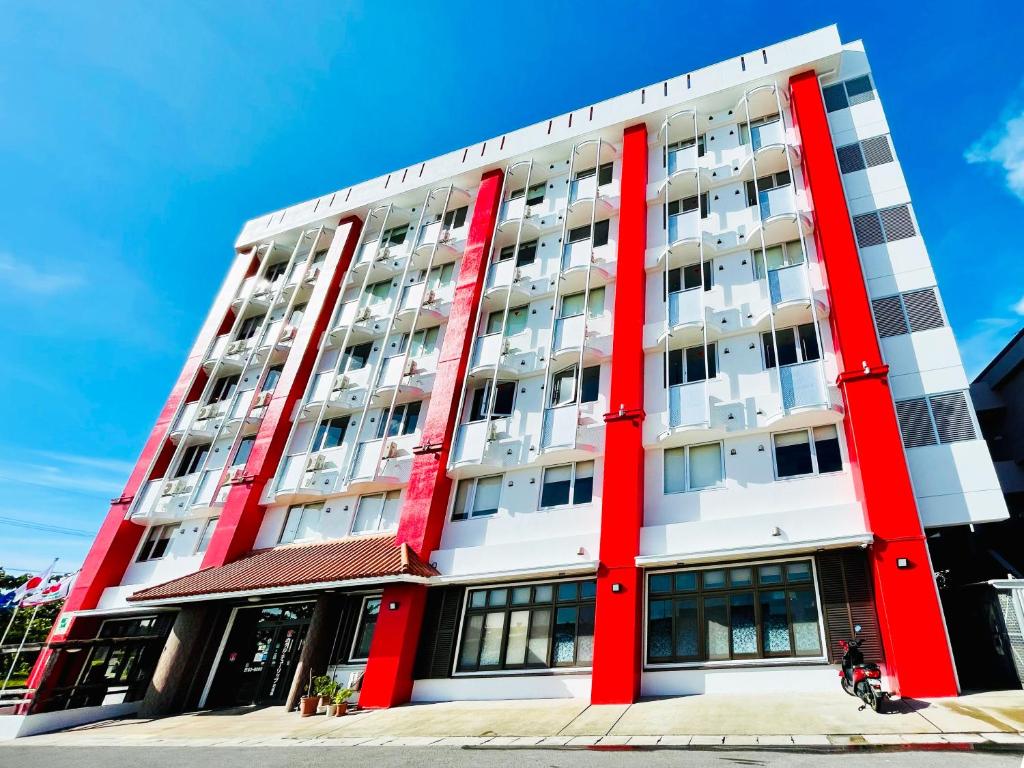 a large red and white building on a street at Hotel Tulip Ishigakijima in Ishigaki Island