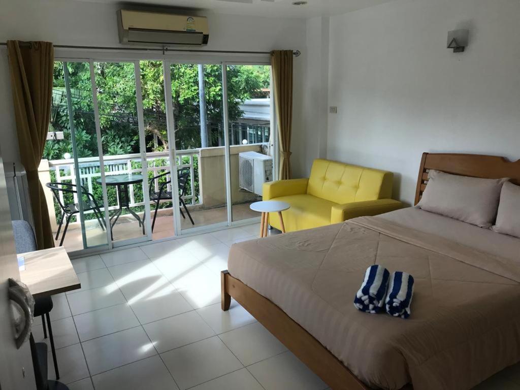 ein Schlafzimmer mit einem Bett und einem gelben Stuhl in der Unterkunft K2 Seaside Suites in Pattaya South