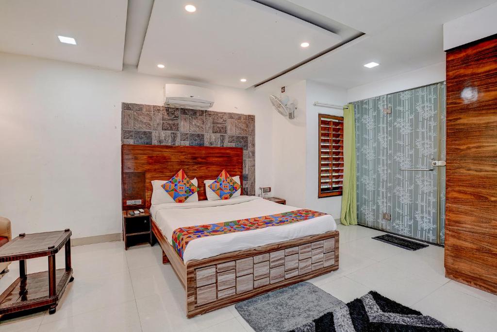 a bedroom with a large bed with a wooden headboard at FabHotel Vardhan House in Pune