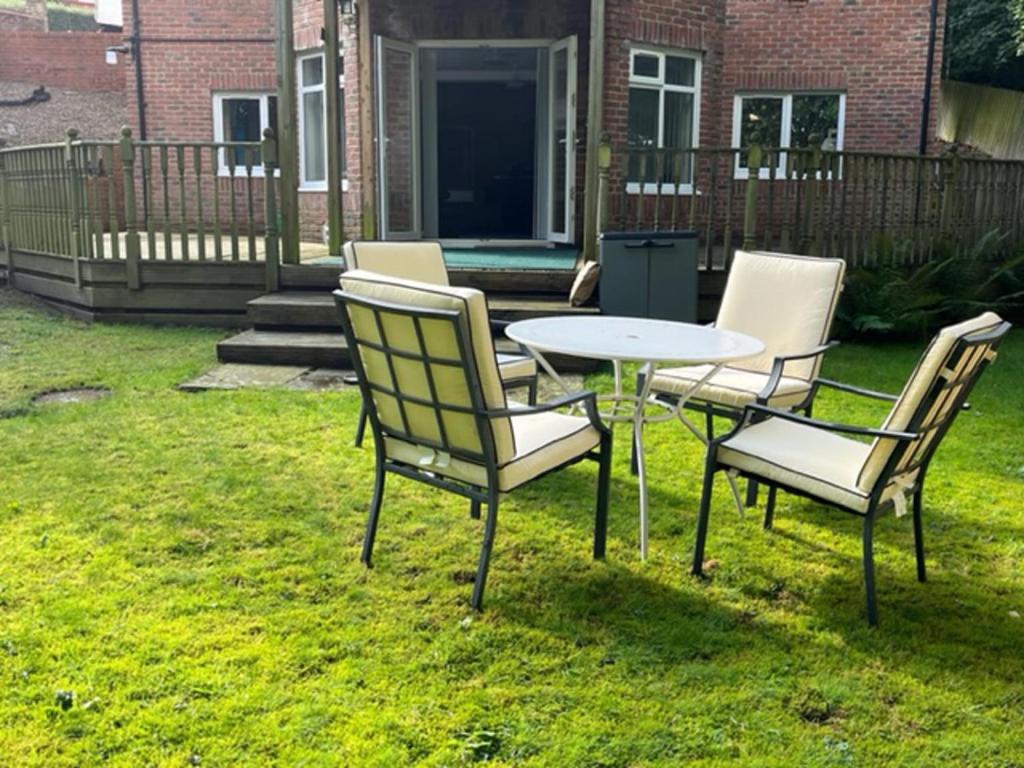 a table and chairs in the grass in a yard at Beautiful 2 Bed Apt with Hot Tub in Blaydon Burn in Blaydon