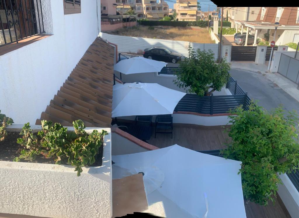 two images of a building with a white roof at Vicino al mare in Santa Pola
