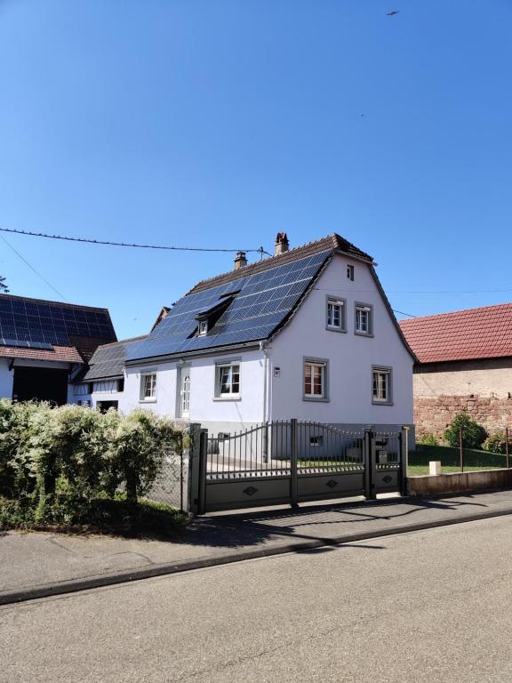 a white house with solar panels on the roof at House MayFa in Riedseltz
