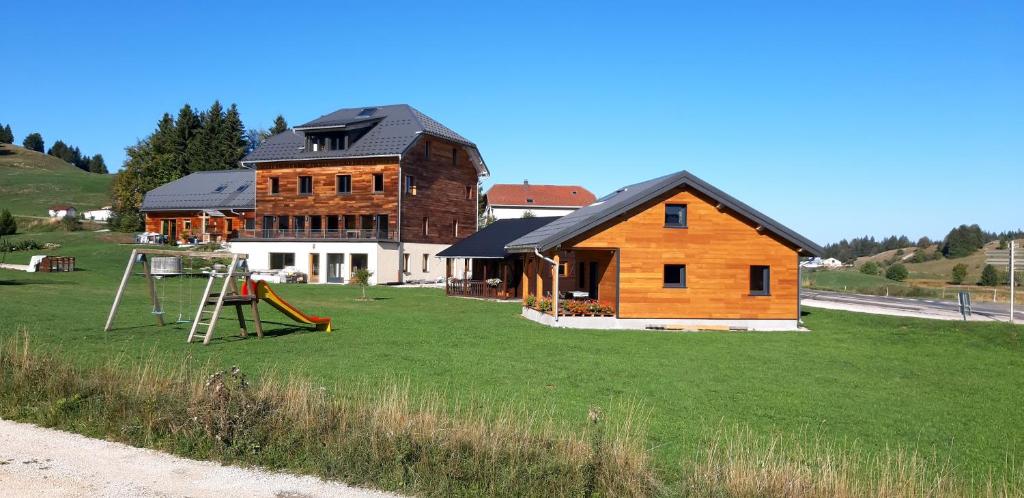 une maison sur une colline avec une aire de jeux devant elle dans l'établissement L étincelle du Manon, à Lajoux