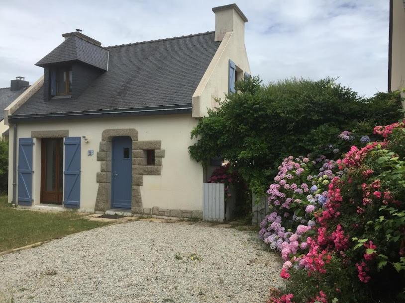 une petite maison avec une porte bleue et quelques fleurs dans l'établissement Keryanne, à Saint-Gildas-de-Rhuys