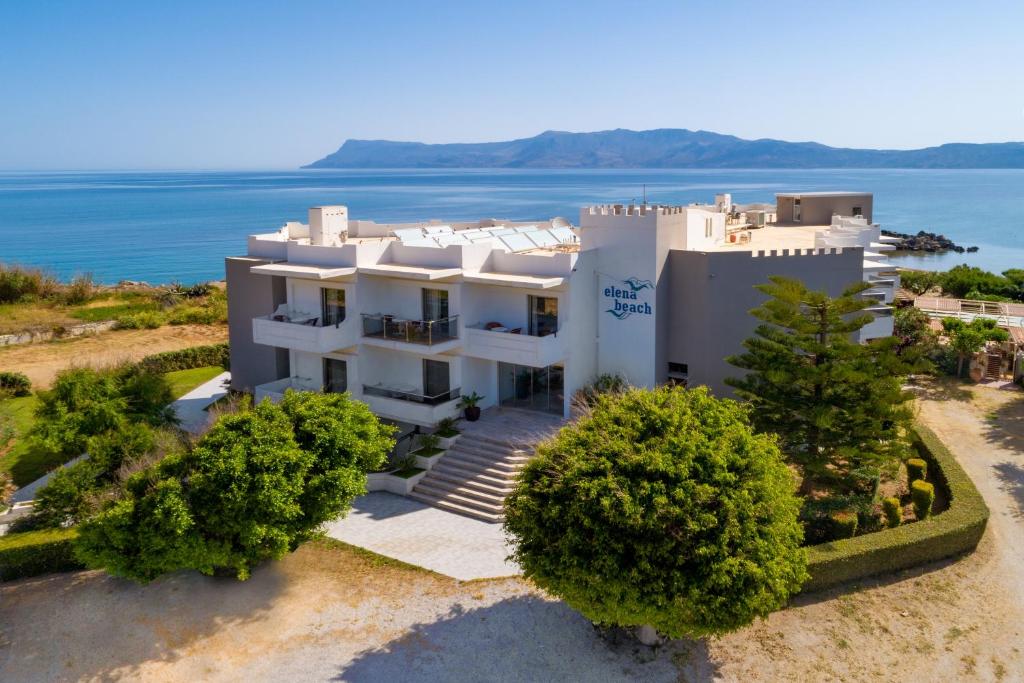 - une vue aérienne sur une maison blanche avec l'océan dans l'établissement Elena Beach Hotel, à Kíssamos