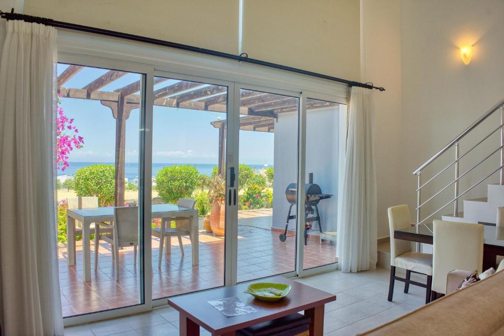 a living room with a sliding glass door leading to a patio at Joya Cyprus Maroon Garden Apartment in Saint Amvrosios