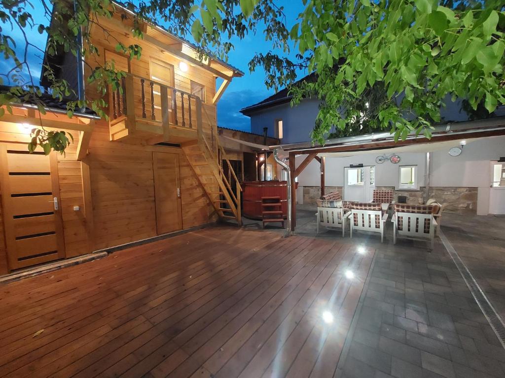 an outdoor patio with a wooden deck and a house at E-Tekergők Háza in Bükkzsérc