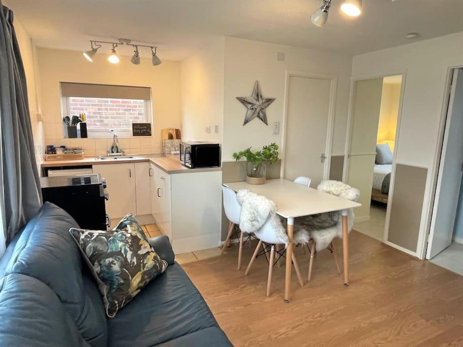 a living room with a table and a kitchen at 126 Hemsby Holiday Chalet, Convenient for sandy beach in Hemsby