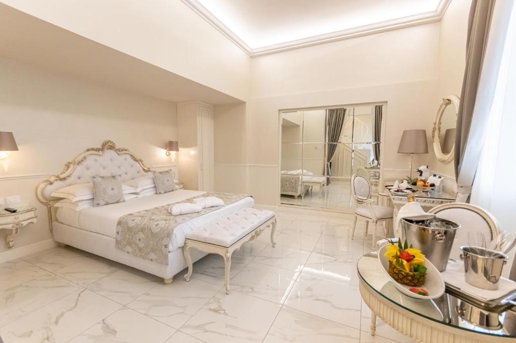 a white bedroom with a bed and a bathroom at The Moon Boutique Hotel & Spa in Florence