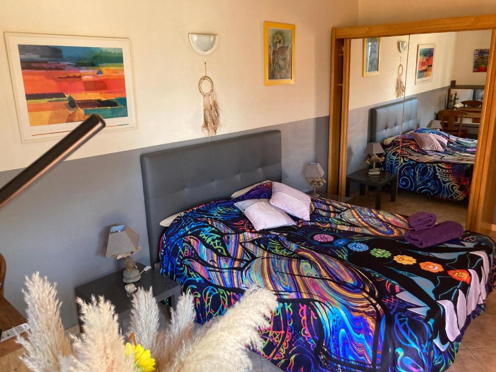a bedroom with a bed with a colorful blanket at B&B Macchia Verdata avec piscine in Monacia-dʼAullène