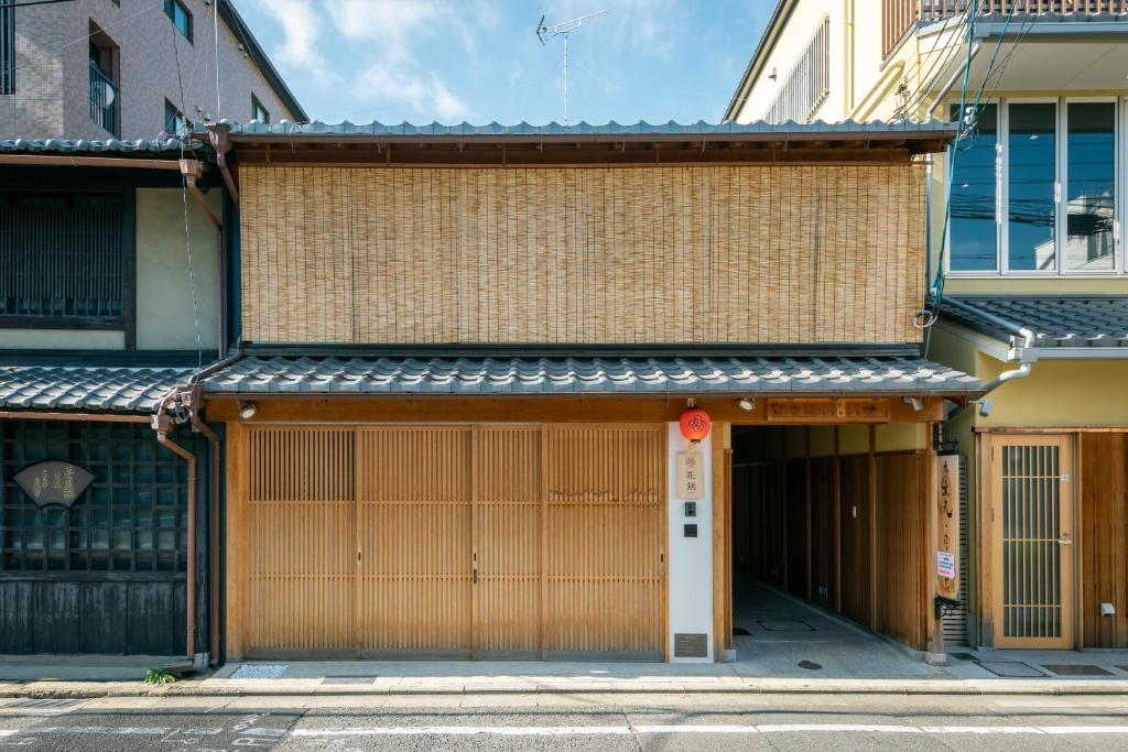a building with two garage doors on a street at Hanatoki Machiya House in Gionmachi