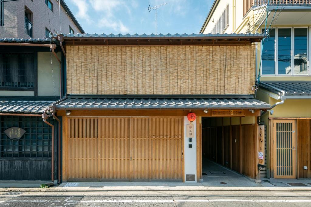 a building with two garage doors on a street at Hanatoki Machiya House in Kyoto