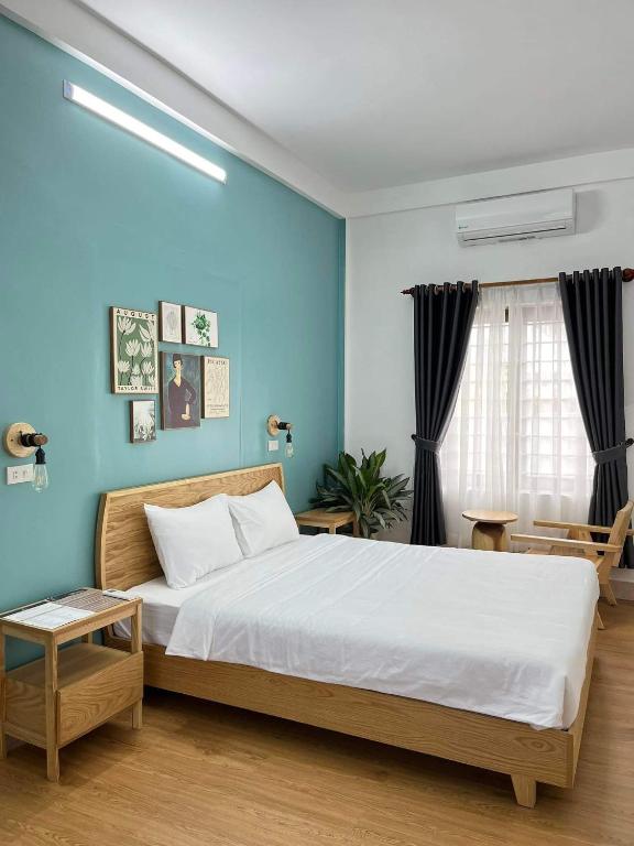 a bedroom with a large bed with blue walls at Hidden Hue Homestay in Hue
