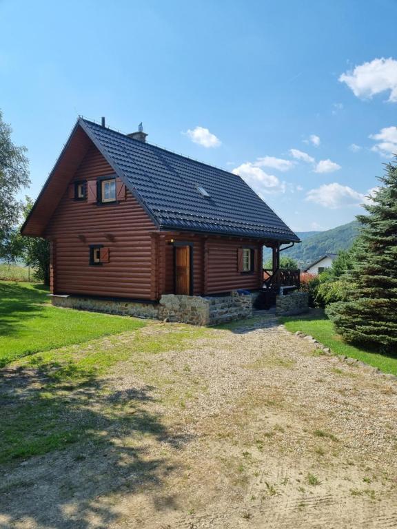 a large wooden house with a large yard at Dom letniskowy Uście Gorlickie in Uście Gorlickie