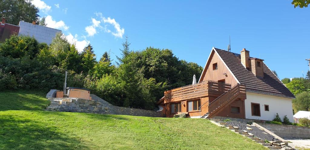 a house sitting on top of a grassy hill at Horský apartmán Draps in Ostružná