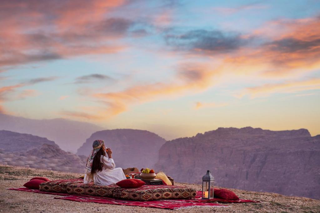 Una coppia stesa su una coperta in montagna di Grand Mercure Petra a Wadi Musa