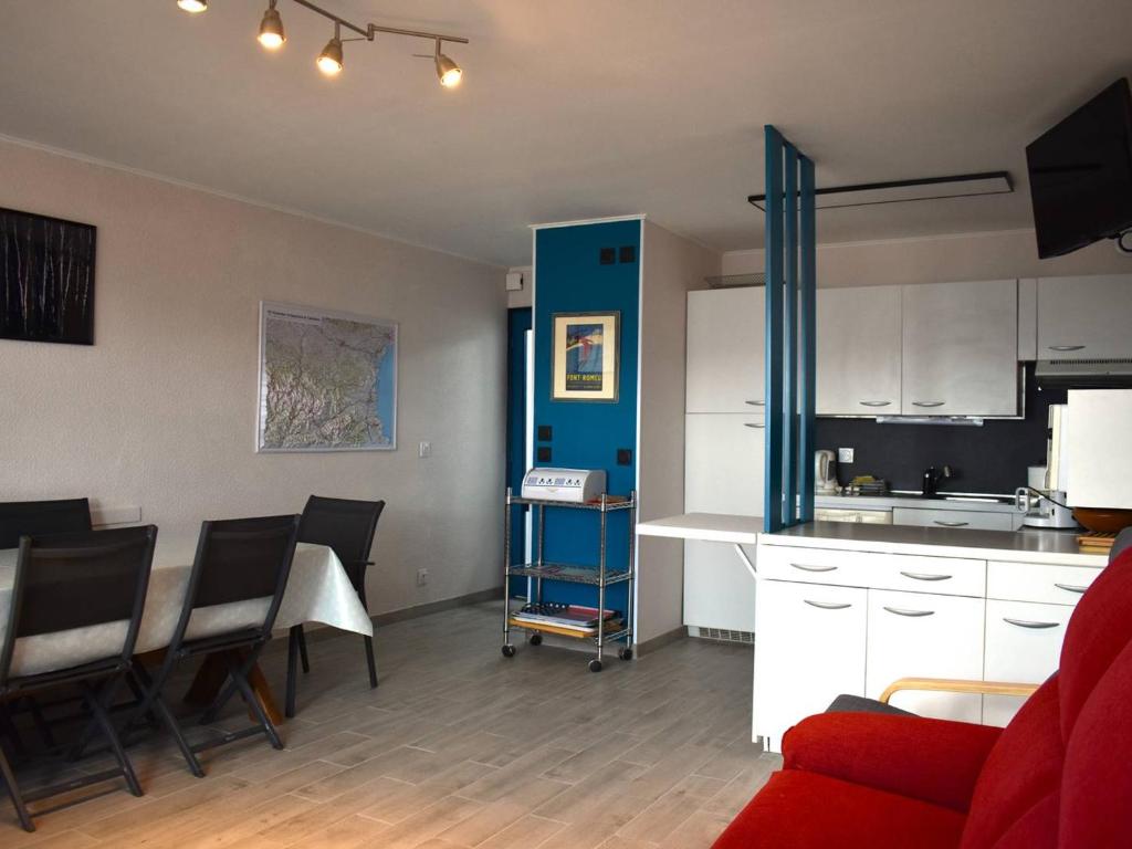 Il comprend une cuisine et un salon avec un canapé rouge. dans l'établissement Appartement Font-Romeu-Odeillo-Via, 4 pièces, 8 personnes - FR-1-580-28, à Font-Romeu-Odeillo-Via