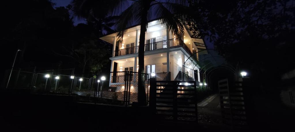 RamakkalmeduShawn Dale Homestay的夜间侧面有灯光的建筑物
