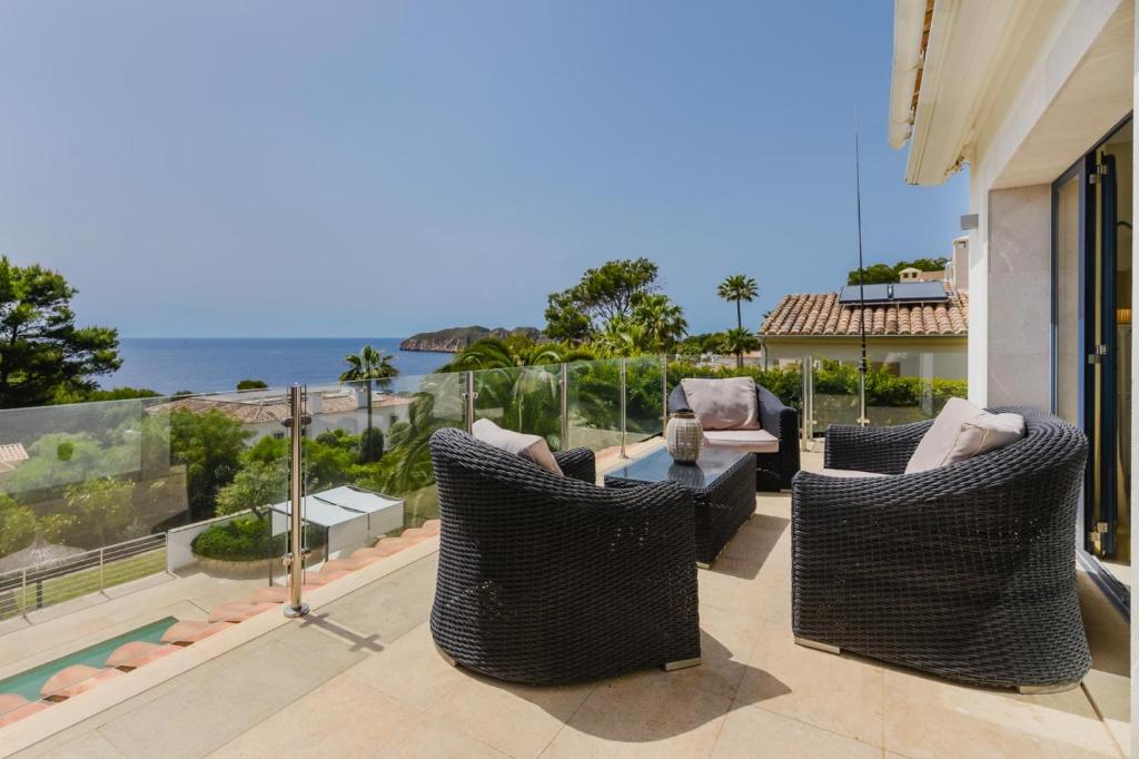 a patio with wicker chairs and a table on a balcony at 2550 Lichtdurchflutete Villa in Santa Ponsa Nova in Santa Ponsa