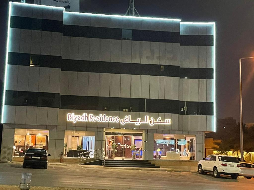 Capital residence في الرياض: مبنى فيه سيارات تقف خارجه بالليل