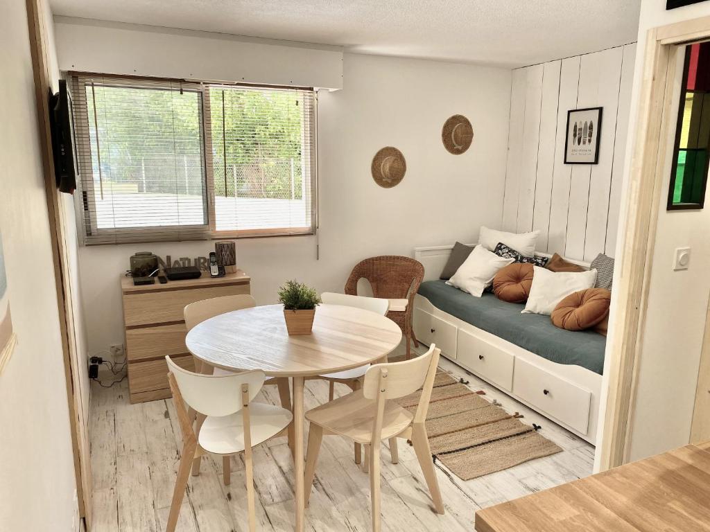 una pequeña sala de estar con mesa y sofá en Charmant appartement rénové 4 couchages Arcachon centre en Arcachón