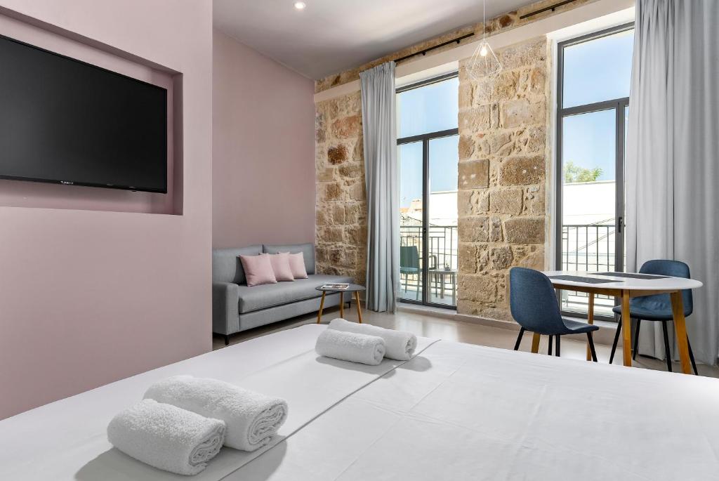 una camera da letto con un grande letto bianco con due cuscini di TheJoy Residence Apartments a Chania