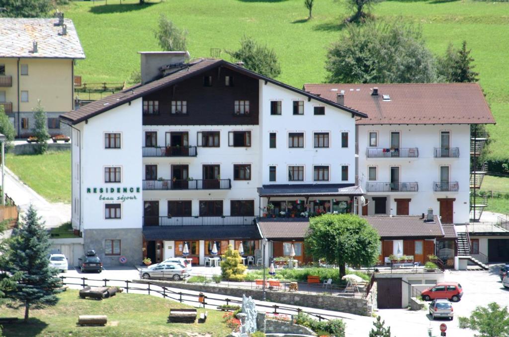 a large white building with a black roof at Residence Beau Sejour in Antey-Saint-André