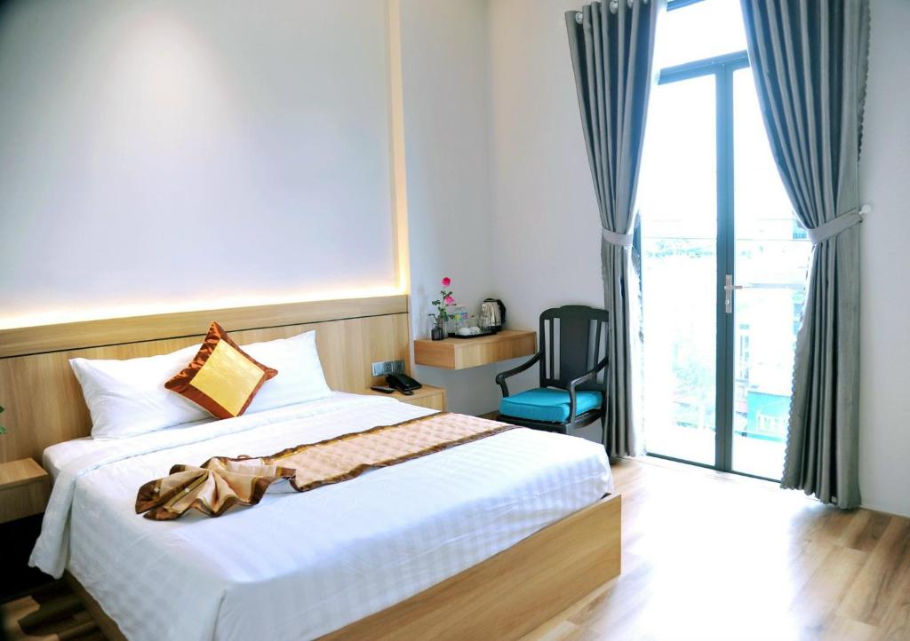 a bedroom with a bed and a large window at Khách Sạn LUCIEN HOTEL Quy Nhơn in Quy Nhon