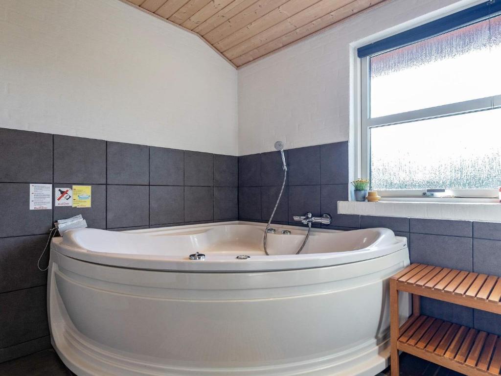 a large white tub in a bathroom with a window at 8 person holiday home in Fjerritslev in Fjerritslev