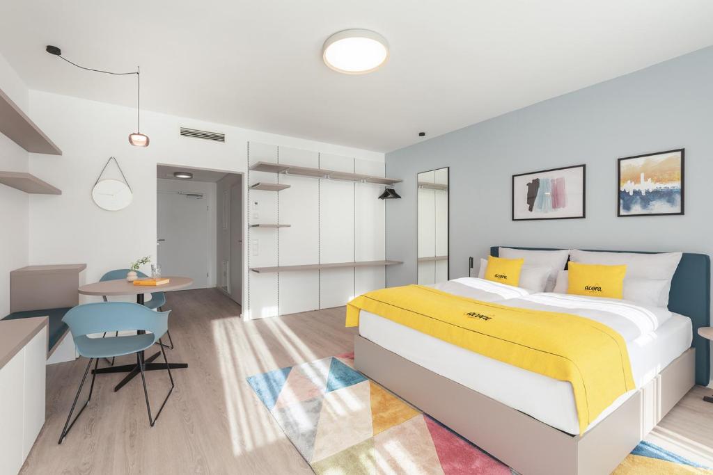 a bedroom with a large bed and a table at acora Heidelberg Living the City in Heidelberg