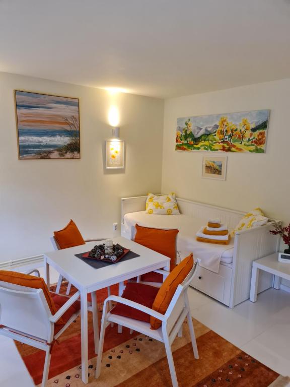 - un salon avec une table et des chaises blanches dans l'établissement Apartamentul ALB, à Buşteni