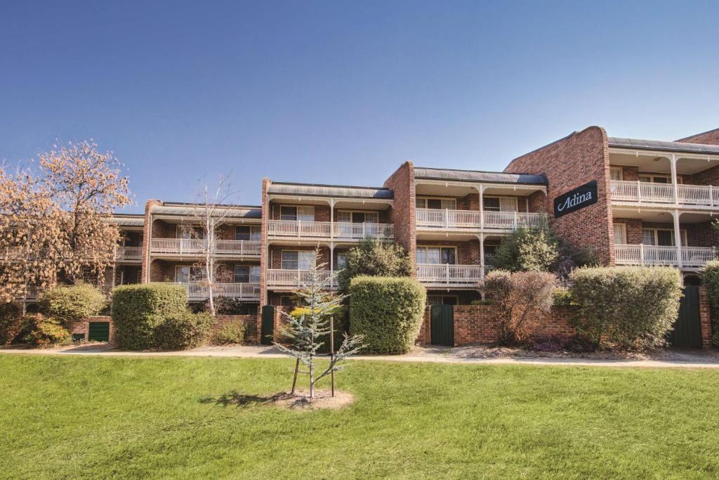 an apartment building with a lawn in front of it at Adina Serviced Apartments Canberra Kingston in Canberra
